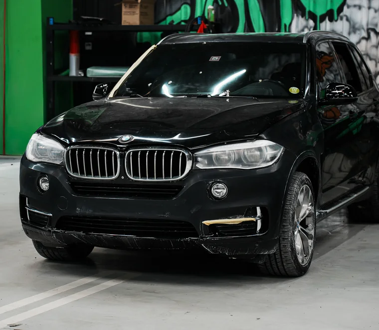 A BMW X5 in a service bay at the System X Car Care workshop in Al Quoz, Dubai
