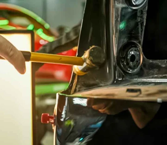 Paintless dent repair being carried out on a car panel in Al Quoz, Dubai, Abu Dhabi